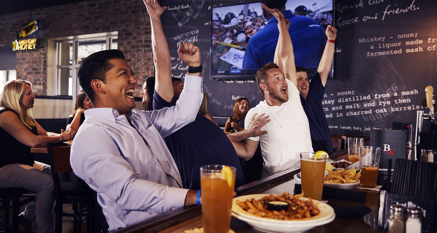 Excited fans at Big Whiskey's American Restaurant & Bar celebrate a score on gameday.