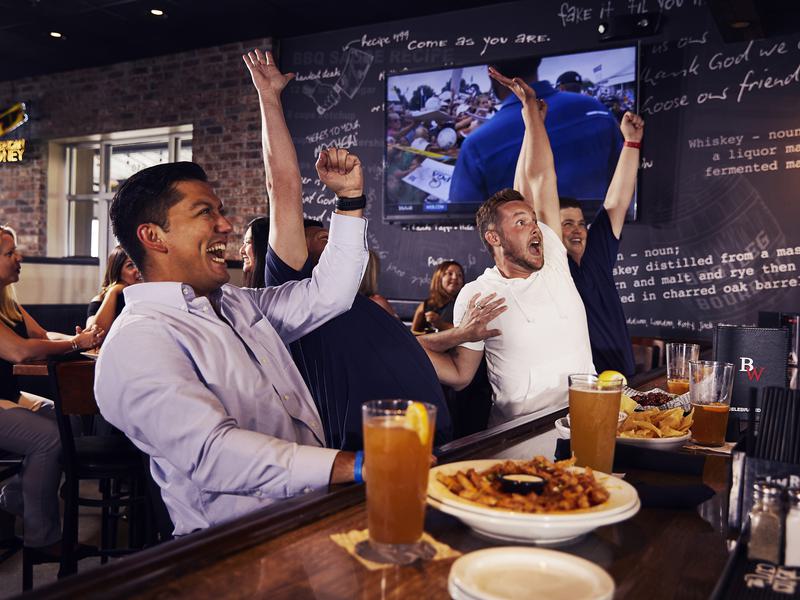 Excited fans at Big Whiskey's American Restaurant & Bar celebrate a score on gameday.
