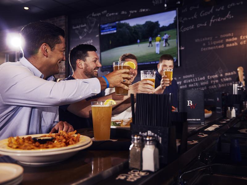 Friends celebrate the local happy hours specials at Big Whiskey's American Restaurant & Bar gameday menu.